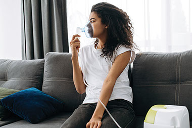 Women sitting with a portable oxygen mask.