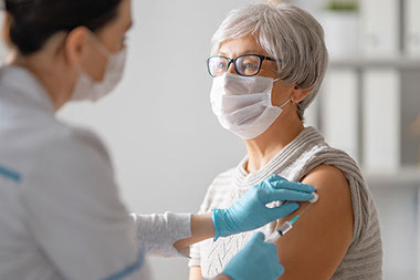 Older female receiving vaccine shot. Older female receiving vaccine shot.