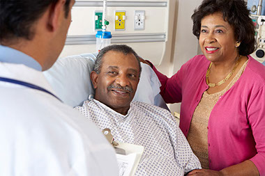 Image of doctor talking to hospital patient and spouse.