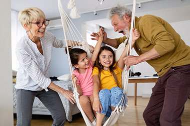 Grandparents playing with 2 young grandkids.