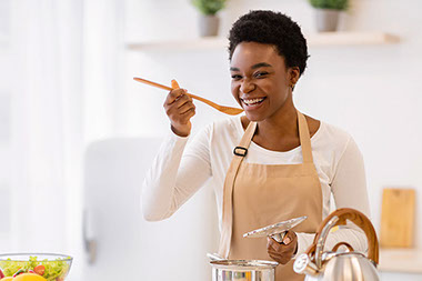 Women trying food from pot. Women trying food from pot.