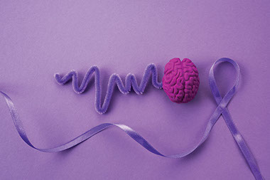 Purple ribbon and brain to represent epilepsy awareness.