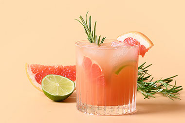 Cocktail drink with slices of grapefruit and lime.