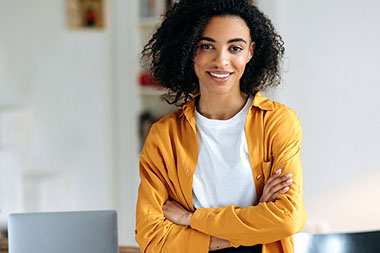 Smiling women with arms crossed.