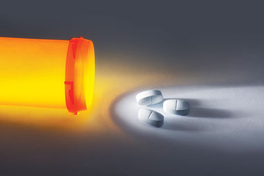Rx painkillers deaths on the rise. Image of open pill bottle with 3 pills next to the bottle.
