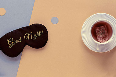 A cup of tea and an eye mask with the word "Good Night!"
