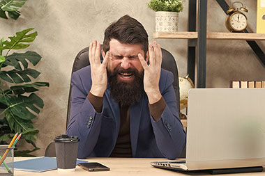 Man stressing out in front of laptop.