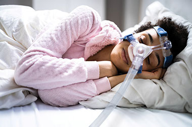 Women wearing a CPAP mask while sleeping.