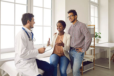 Young couple talking to doctor.