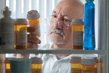 Can you pass this drug test? Image of man looking in his medicine cabinet.