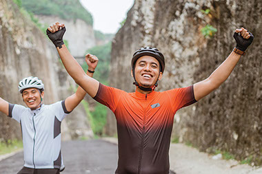 Two men with hands in the air sitting on bikes. Two men with hands in the air sitting on bikes.