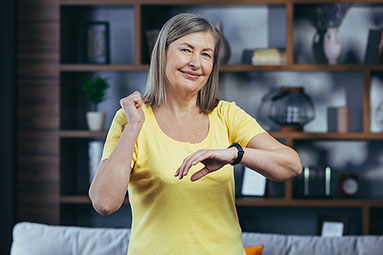 Women with smart watch and fist up in the air.