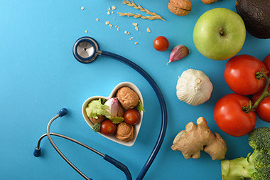 Heart shape plate filled with walnuts, tomatoes, apple, garlic, etc.