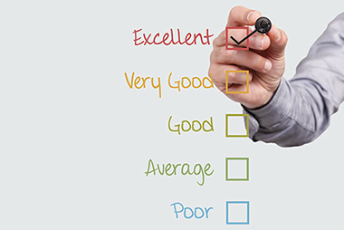 Overcome perfectionism. A list of words with a mans hand checking off the "Excellent" box.