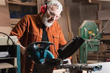 Man wearing protective eye and hearing gear while using machinery.