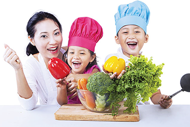 Image of mother with 2 young kids wearing chef hats.