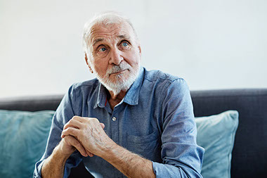 Man sitting looking up and sideways.
