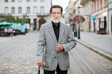 Older man standing in middle of road.