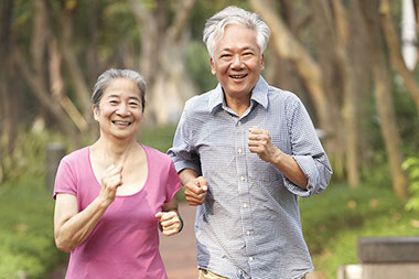 Image of older Asian couple brisk walking.