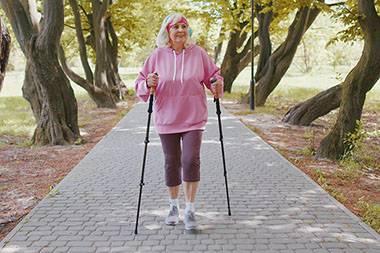 Older women on a walk and using walking sticks.