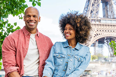 Couple smiling, sitting in front of eiffel tower. Couple smiling, sitting in front of eiffel tower.