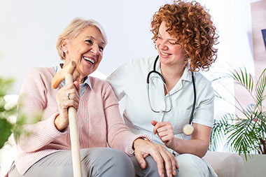 Nurse with older women holding a cane.