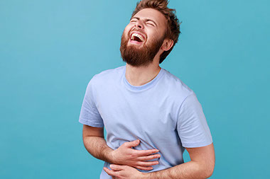 Man holding stomach as he laughs out loud. Man holding stomach as he laughs out loud.