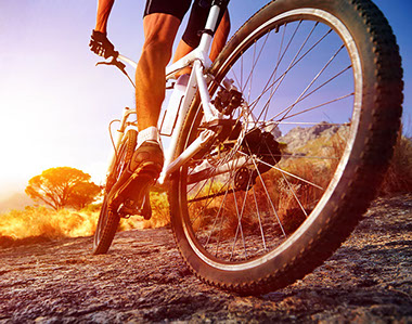A closeup image of a bike tire while a cyclist rides through a trail.
