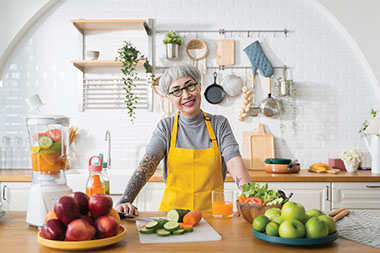 Women in kitchen with fresh food on counter. Women in kitchen with fresh food on counter.