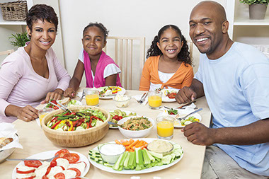 What is a serving size, anyway. Image of family eating dinner.