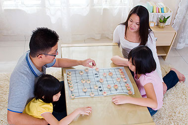 Image of family playing a game at the living room table.