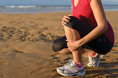 Image of women holding her shin.