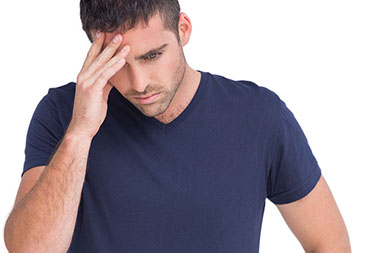 Image of man with hand on head.
