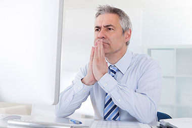 Image of man thinking at desk.