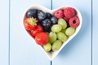 Selection of fruits in a heart shaped bowl.