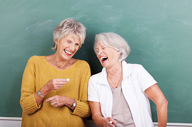 Image of two mature women laughing.