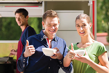 Couple enjoying snacks at an outdoor event.