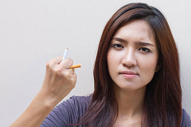 Women crushing cigarette in hand.