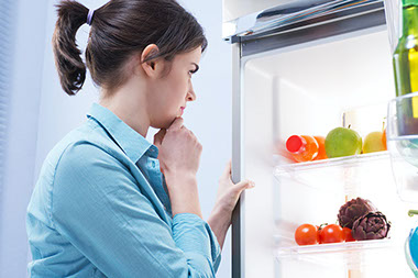 Image of women looking inside refrigerator.