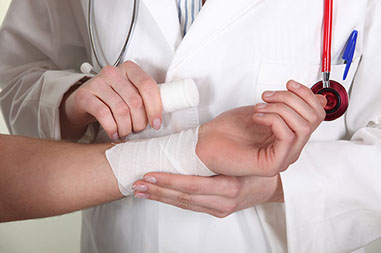 Close-up image of a doctor wrapping up a burn on a patients arm.