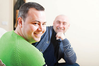 Listening: A skill well worth mastering. Image of 2 men talking and smiling.