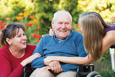 Image of eldery man in wheelchair with daughter and granddaughter.