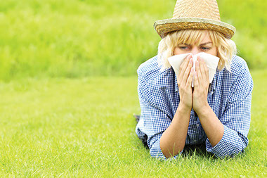 Women outside blowing her nose.