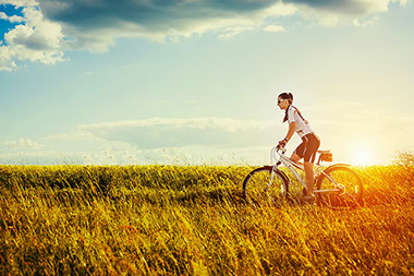 Women riding bike in the fields.
