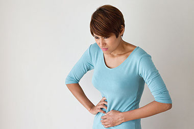 Image of women holding her stomach in pain.