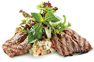 Two pieces of beef with garnish. Two pieces of beef with garnish.