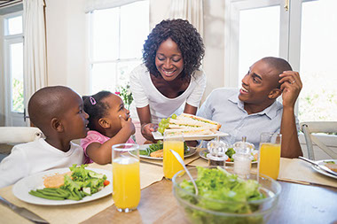 Image of family sitting at the kitchen table eating dinner.