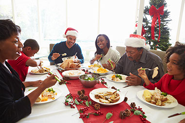 Multi-generation family enjoying christmas meal at home.