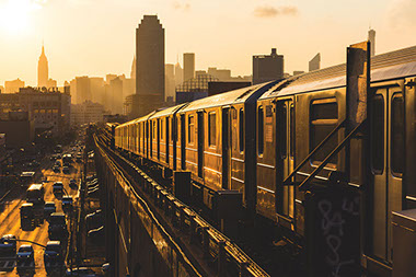 Image of elevated train and cars on road.