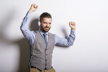 Fun, fast indoor workouts. Image of middle-aged man with headphones on dancing.